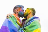 kiss-messy-gay-couple-wrapping-in-rainbow-flags.jpeg
