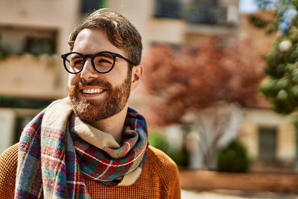 Young caucasian man with beard wearing glasses outdoors on a sun